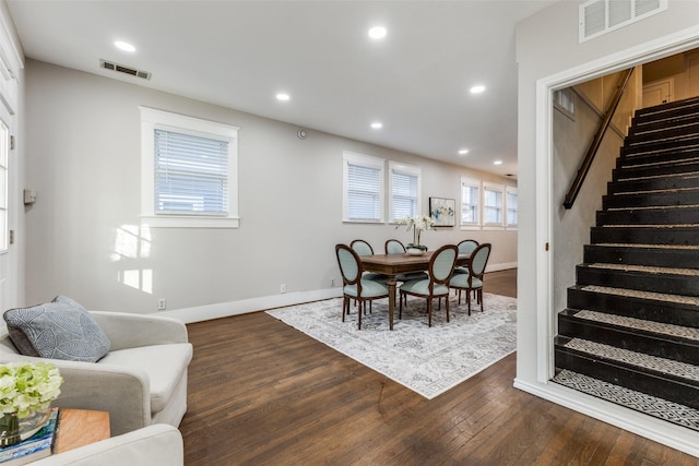 dining area featuring stairs, dark wood-style flooring, baseboards, and visible vents