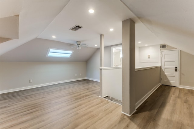bonus room featuring visible vents, wood finished floors, and vaulted ceiling with skylight