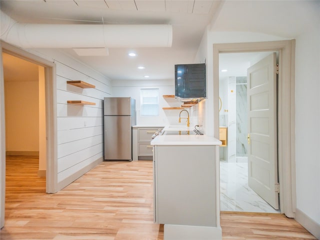 kitchen with light countertops, open shelves, recessed lighting, and freestanding refrigerator