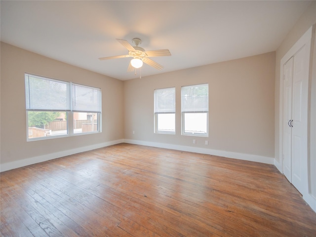 unfurnished bedroom with baseboards, a ceiling fan, light wood-style flooring, and a closet
