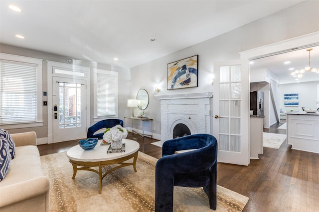 living area with an inviting chandelier, wood finished floors, a fireplace, baseboards, and recessed lighting