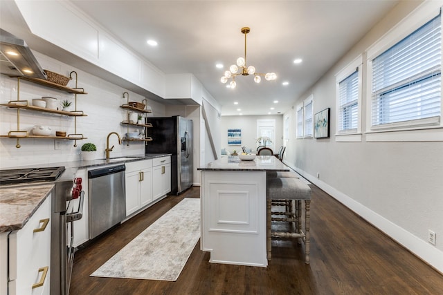 kitchen with a sink, appliances with stainless steel finishes, tasteful backsplash, and stone countertops