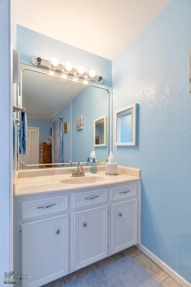 5631 Southmoor Dr, Abilene, TX 79606 - bathroom featuring vanity, a textured wall, baseboards, and tile patterned floors