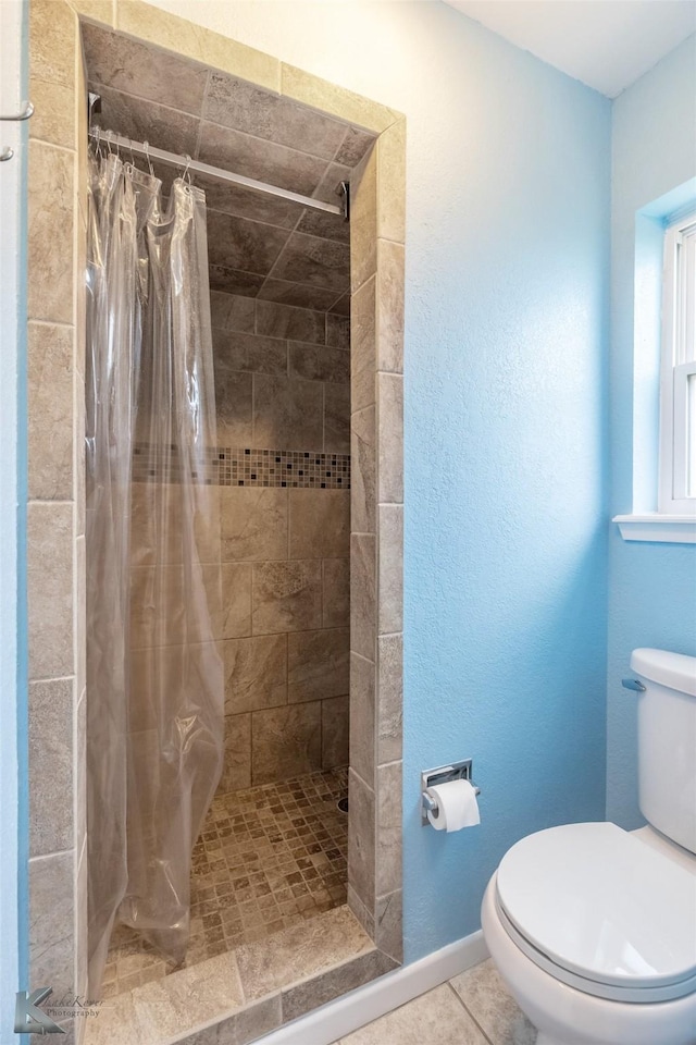 5631 Southmoor Dr, Abilene, TX 79606 - full bathroom featuring baseboards, tile patterned floors, toilet, and a shower stall