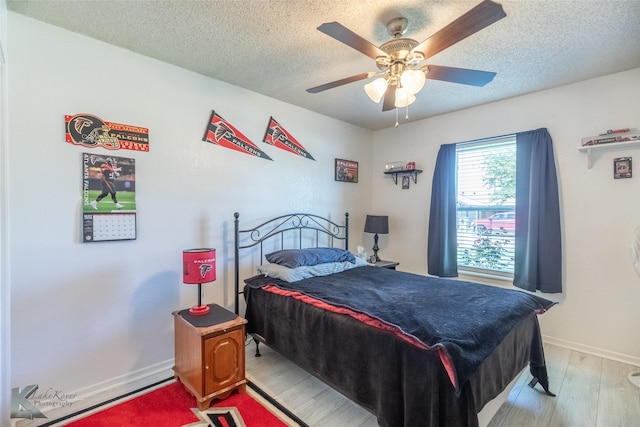 5631 Southmoor Dr, Abilene, TX 79606 - bedroom featuring baseboards, a ceiling fan, light wood-type flooring, and a textured ceiling