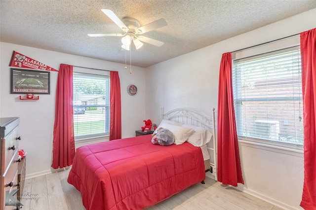 5631 Southmoor Dr, Abilene, TX 79606 - bedroom with baseboards, light wood-style flooring, a textured ceiling, and a ceiling fan