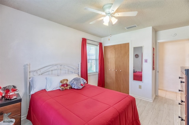 5631 Southmoor Dr, Abilene, TX 79606 - bedroom with ceiling fan, light wood finished floors, a textured ceiling, visible vents, and a closet