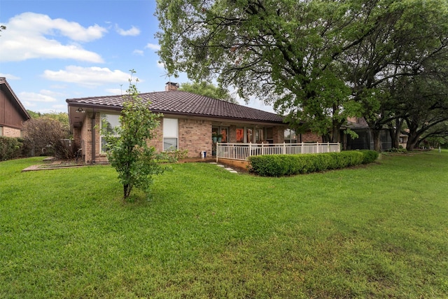 832 Havenwood Ln S, Fort Worth, TX 76112 - back of house with a tiled roof, brick siding, a chimney, and a lawn