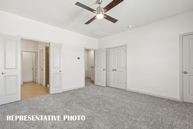 unfurnished bedroom featuring carpet floors, baseboards, a ceiling fan, and visible vents