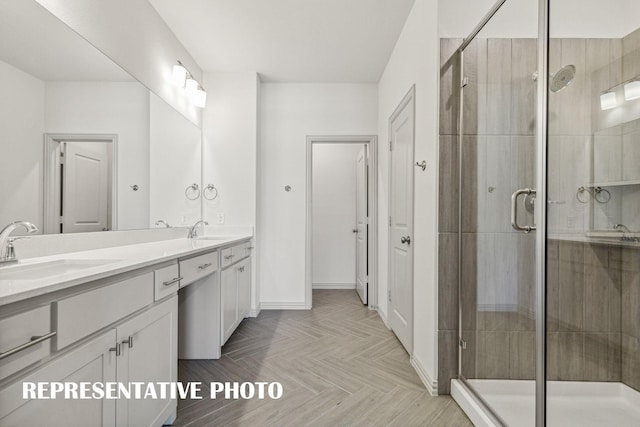 full bath with double vanity, a sink, baseboards, and a shower stall