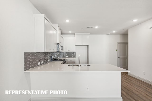 kitchen with visible vents, a peninsula, light countertops, a sink, and appliances with stainless steel finishes