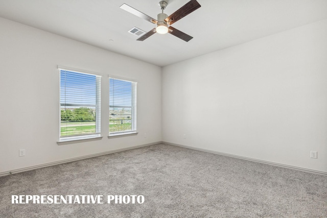 spare room featuring baseboards, a ceiling fan, carpet flooring, and visible vents
