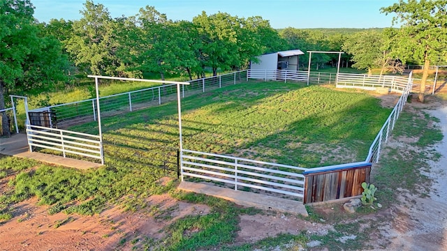 view of yard with an outbuilding, an exterior structure, and a rural view