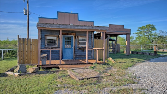view of outbuilding with fence and an outbuilding