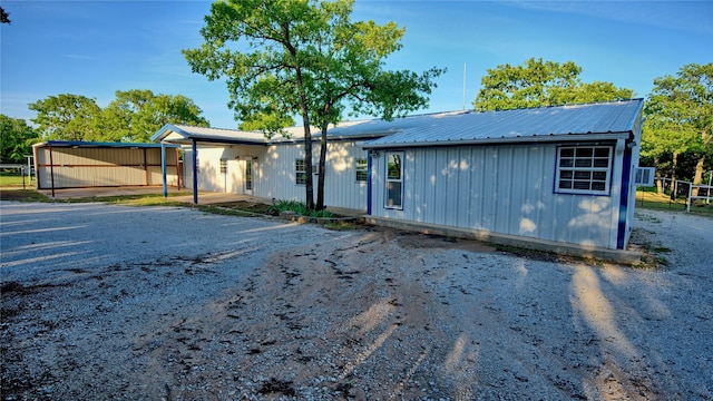 manufactured / mobile home featuring board and batten siding, fence, and metal roof