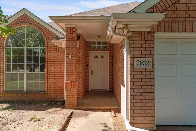 7632 Arbor Ridge Ct, Fort Worth, TX 76112 - doorway to property featuring an attached garage, brick siding, and a shingled roof