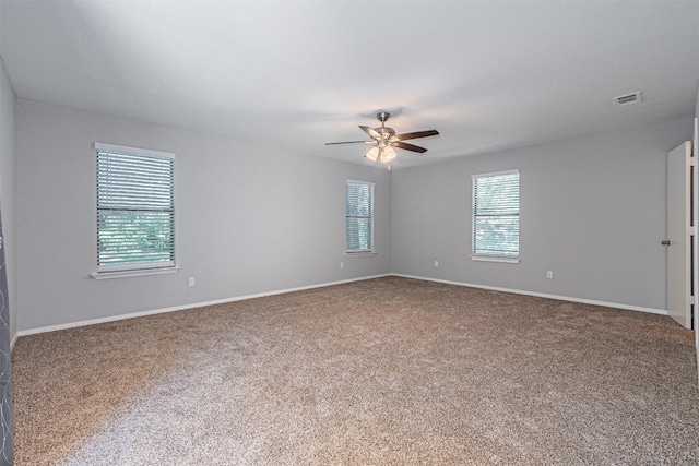 spare room featuring ceiling fan, visible vents, baseboards, and carpet