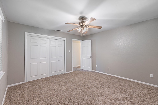 unfurnished bedroom with a closet, carpet flooring, and baseboards