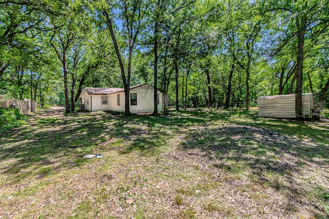 view of yard with fence and an outbuilding