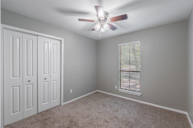 unfurnished bedroom with a ceiling fan, baseboards, carpet, and a closet