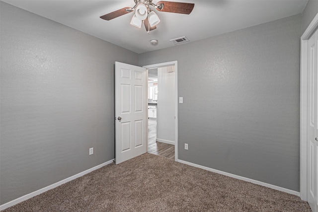 unfurnished room with visible vents, carpet, ceiling fan, and baseboards