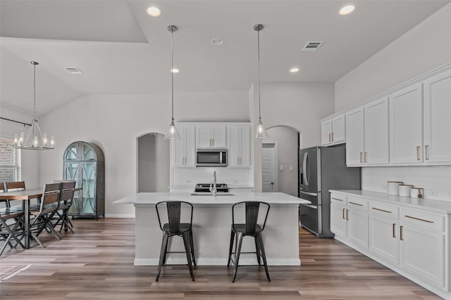 kitchen featuring visible vents, appliances with stainless steel finishes, arched walkways, light countertops, and white cabinetry
