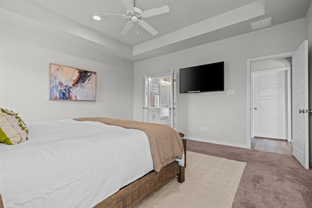 carpeted bedroom featuring connected bathroom, a raised ceiling, recessed lighting, baseboards, and visible vents