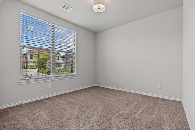carpeted empty room with visible vents and baseboards