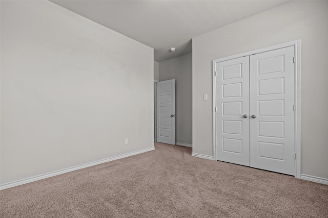 unfurnished bedroom with a closet, carpet, and baseboards