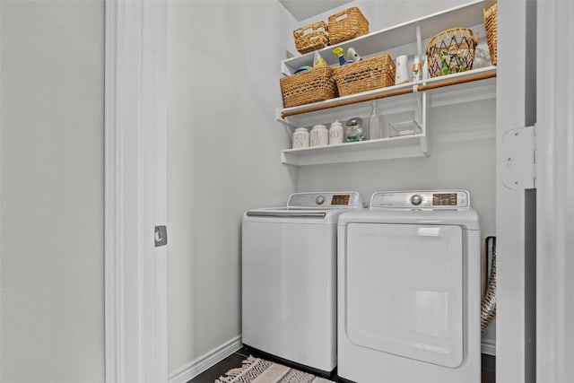 clothes washing area featuring baseboards, laundry area, and washer and clothes dryer