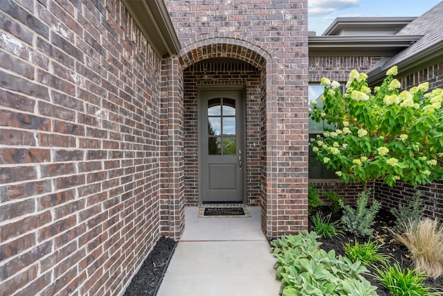 view of exterior entry featuring brick siding