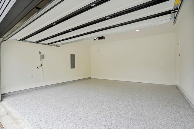 garage featuring electric panel and baseboards