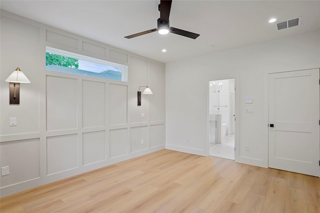 unfurnished bedroom with light wood finished floors, visible vents, a decorative wall, and recessed lighting