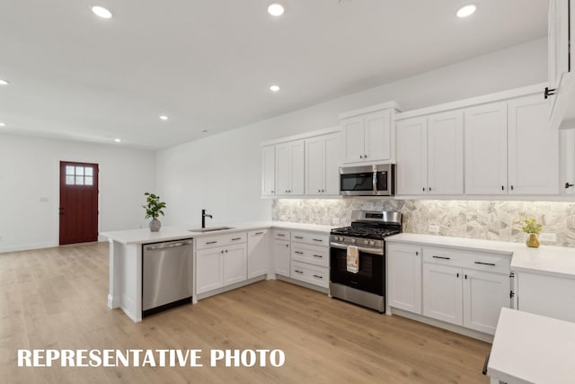 kitchen featuring white cabinets, a peninsula, and appliances with stainless steel finishes
