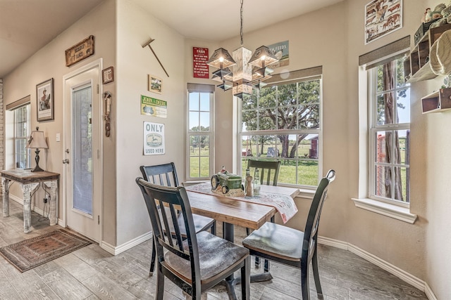 dining area with plenty of natural light, baseboards, and wood finished floors