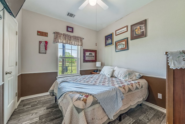 bedroom featuring visible vents, a ceiling fan, baseboards, and wood finished floors