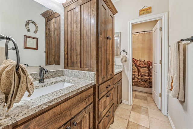 full bathroom with baseboards, tile patterned floors, and vanity