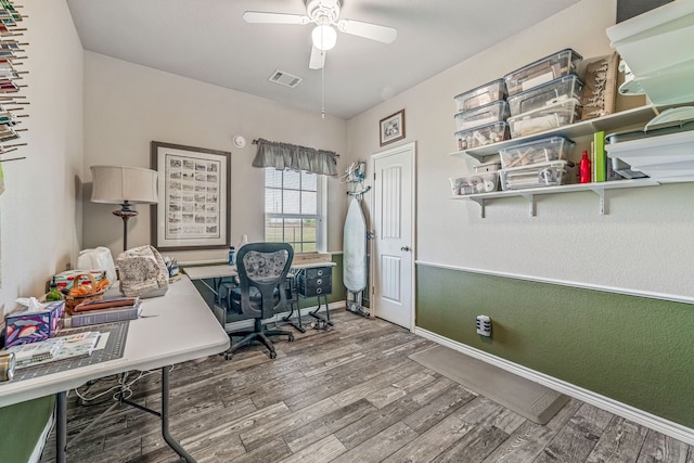office space with a ceiling fan, baseboards, visible vents, and wood finished floors