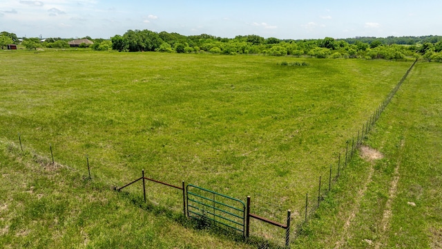 view of yard with fence and a rural view