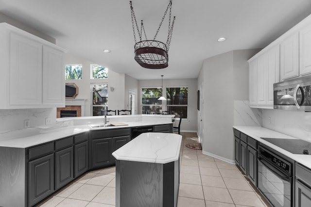 907 Ozark Dr, Allen, TX 75002 - kitchen with a sink, black appliances, a peninsula, light tile patterned flooring, and white cabinetry