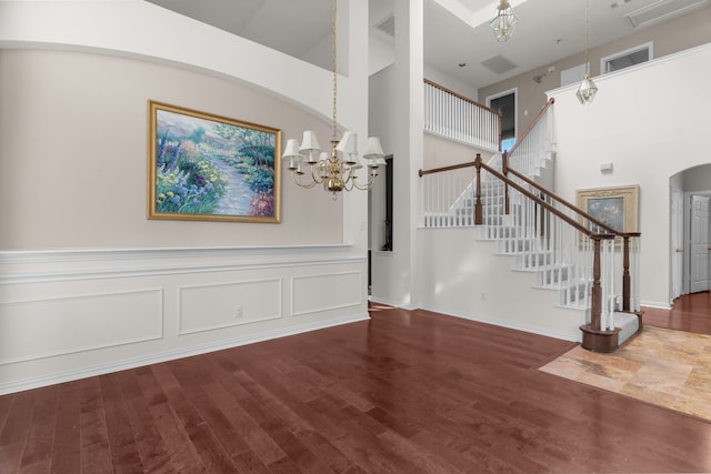 907 Ozark Dr, Allen, TX 75002 - interior space with a towering ceiling, arched walkways, wood finished floors, a notable chandelier, and stairs