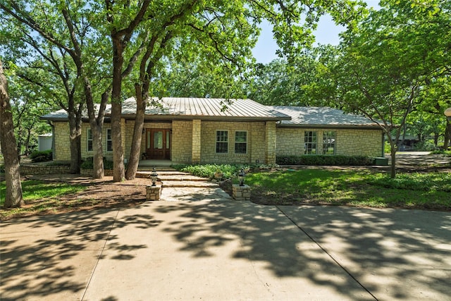 view of front of house featuring metal roof and stone siding