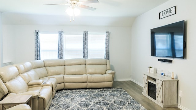 living room featuring baseboards, ceiling fan, and wood finished floors