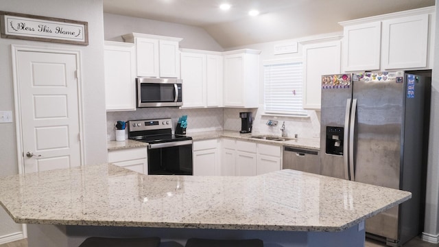 kitchen with stainless steel appliances, decorative backsplash, a sink, and a kitchen bar