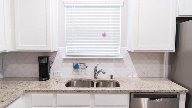 kitchen featuring a sink, appliances with stainless steel finishes, tasteful backsplash, and white cabinetry