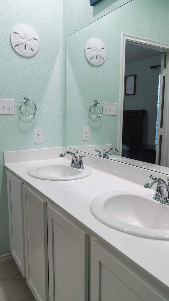 full bathroom featuring double vanity, a sink, and tile patterned flooring