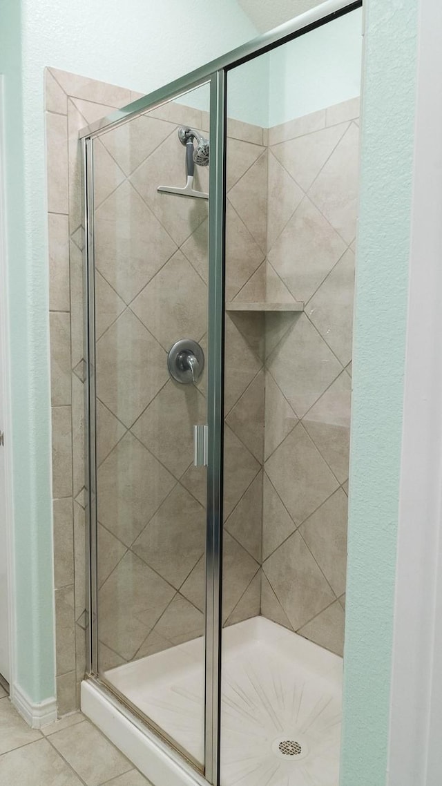 full bathroom with tile patterned floors and a stall shower