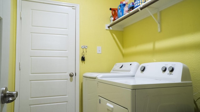 clothes washing area featuring separate washer and dryer and laundry area