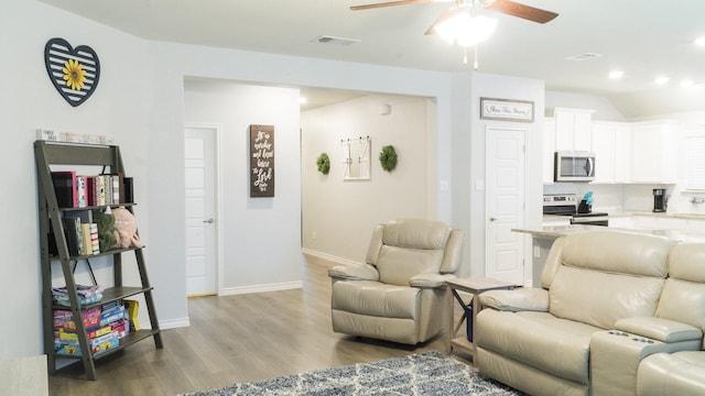 living area with a ceiling fan, visible vents, wood finished floors, baseboards, and recessed lighting