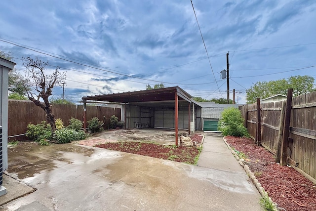 view of outdoor structure with a fenced backyard and a carport